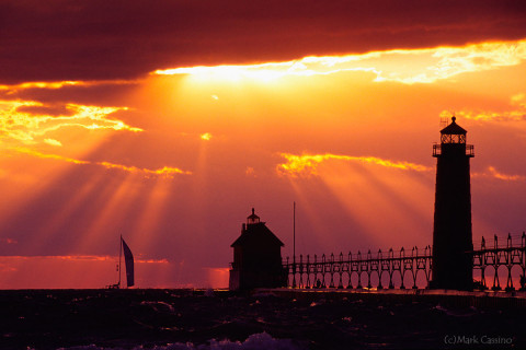 Sailboat in the sunset behind the Grand Haven, Michigan lighthouse.